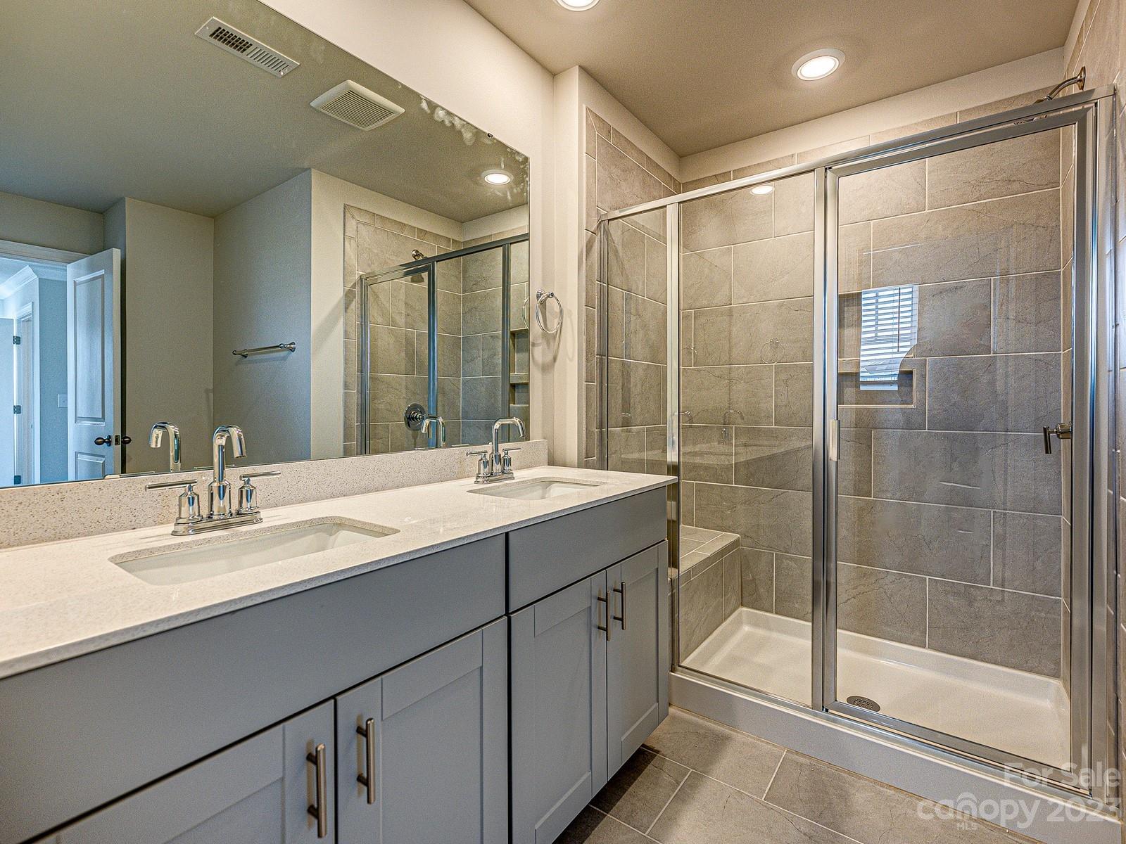 664 Citriadora Street Fort Mill, SC 29715 - Photo 18 of 27 a bathroom with a shower sink and mirror
