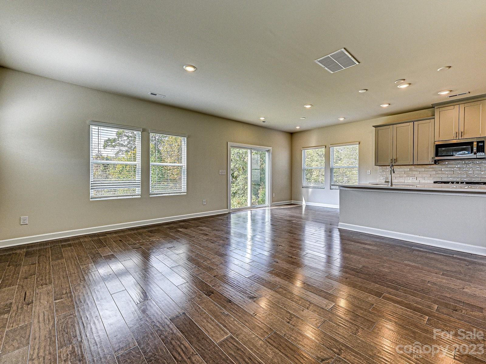 664 Citriadora Street Fort Mill, SC 29715 - Photo 3 of 27 an open kitchen with kitchen island wooden floors and center island