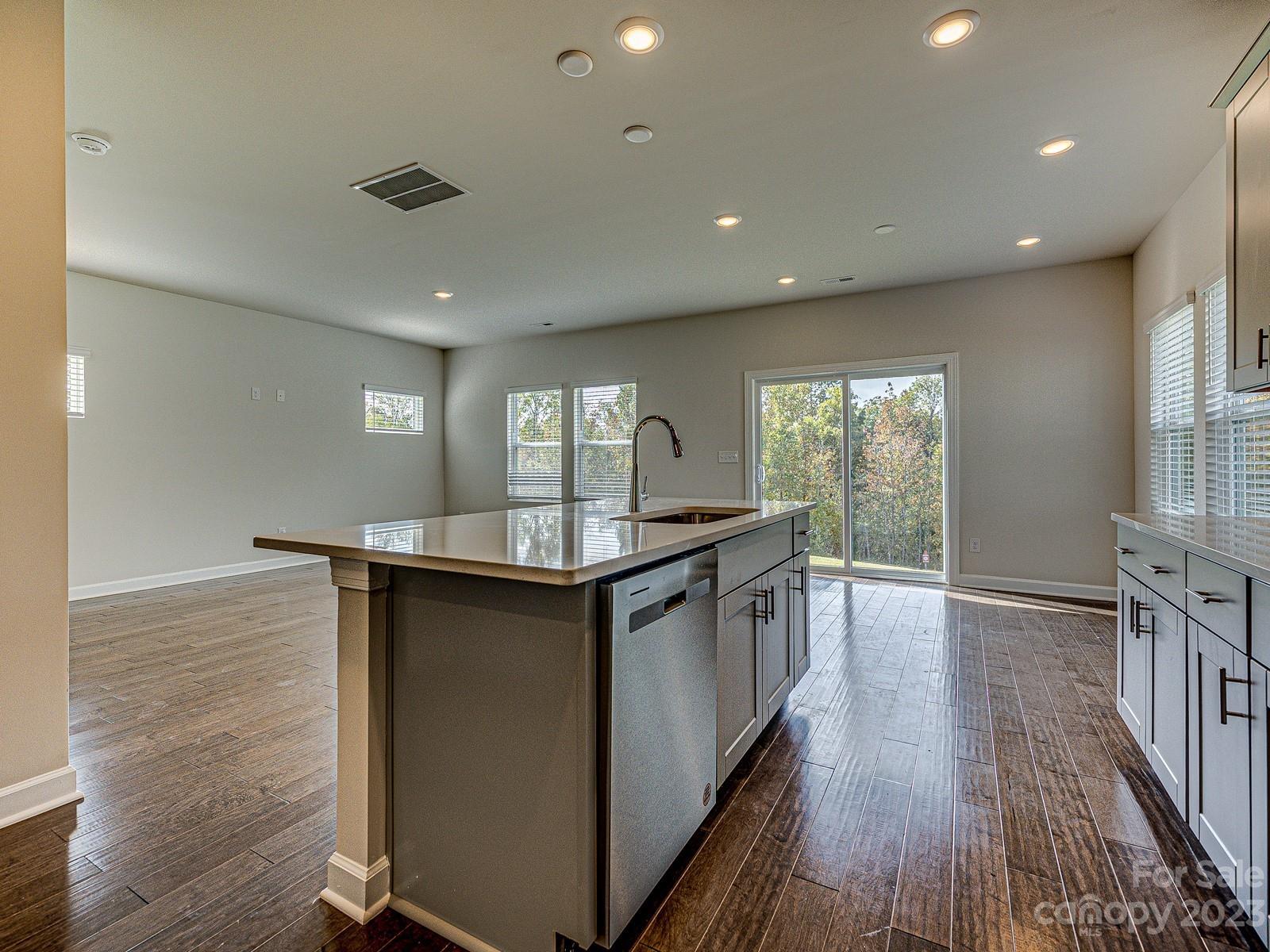 664 Citriadora Street Fort Mill, SC 29715 - Photo 8 of 27 an open kitchen with granite countertop kitchen island wooden floors and stainless steel appliances