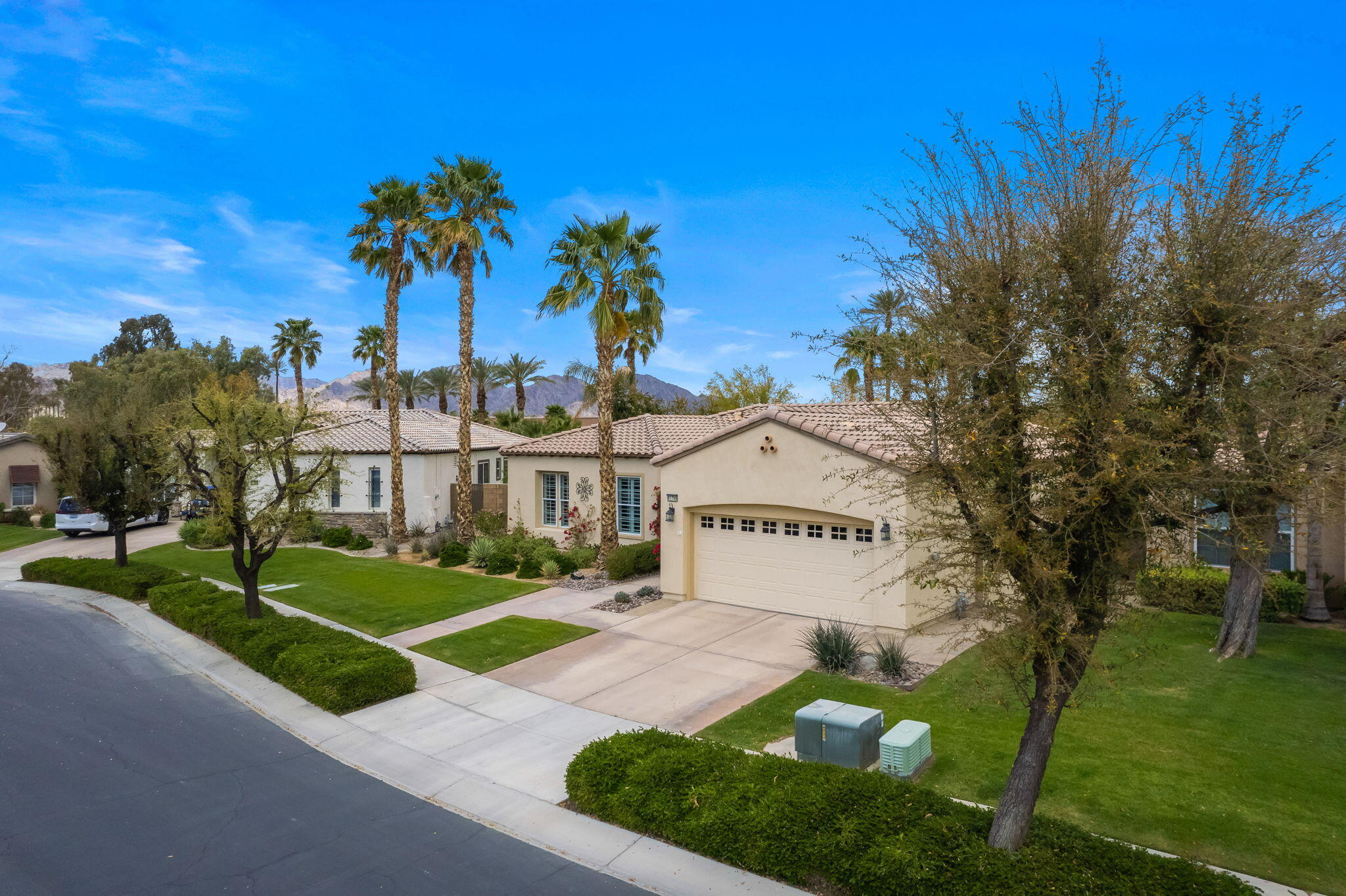81768 Daniel Drive La Quinta, CA 92253 - Photo 39 of 81 a view of a white house with a big yard and palm trees