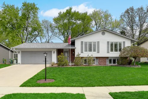 a front view of a house with a garden and yard