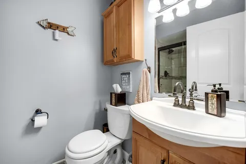 a bathroom with a sink a toilet and mirror