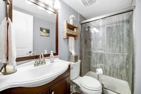 a bathroom with a sink a toilet and shower