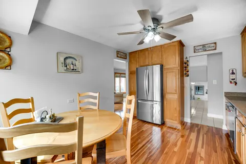a dining room with stainless steel appliances kitchen island granite countertop furniture and a refrigerator