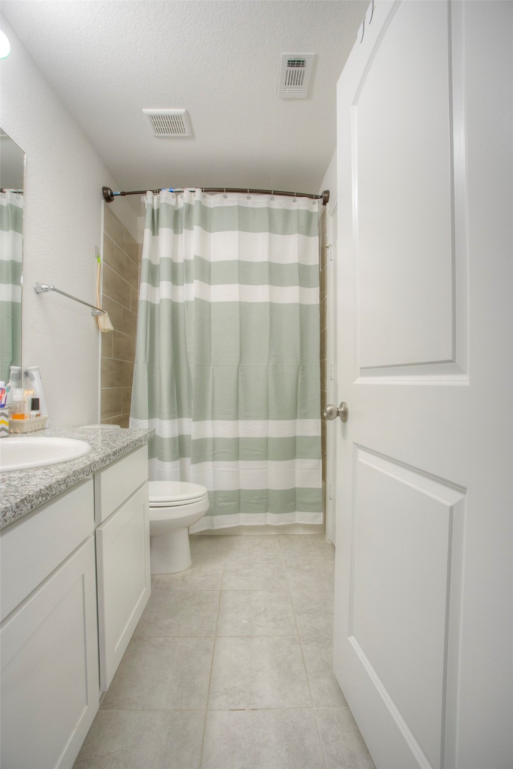 28617 Rantoul Court Point Blank, TX 77364 - Photo 23 of 29 a bathroom with a granite countertop sink a toilet and shower
