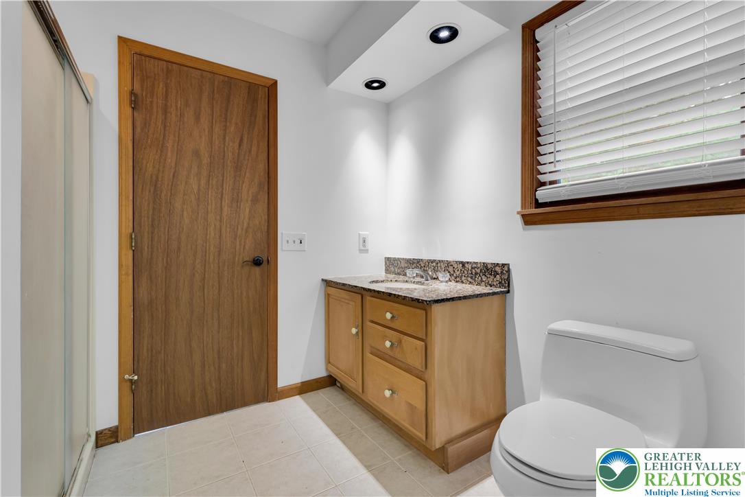 139 Johnny Bee Road Dingmans Ferry, PA 18328 - Photo 33 of 51 a bathroom with a granite countertop toilet sink and mirror