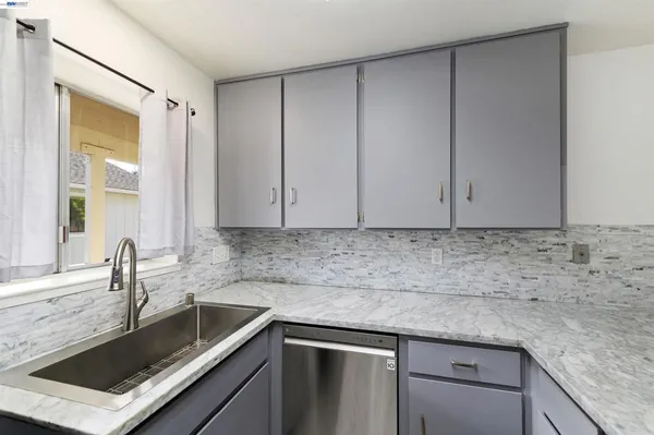 a kitchen with granite countertop a sink and cabinets