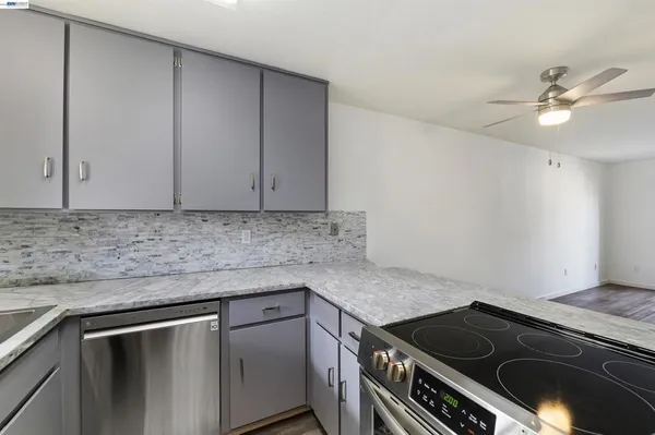a kitchen with granite countertop cabinets stainless steel appliances and a counter space