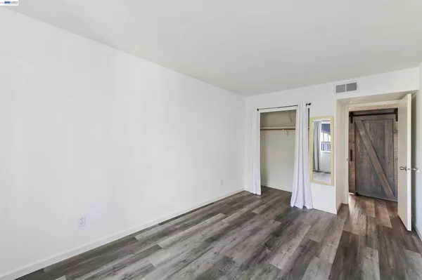 a view of a room with wooden floor and bench