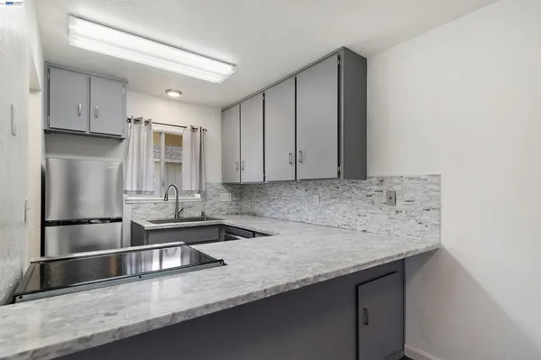 a kitchen with stainless steel appliances granite countertop a sink and a refrigerator