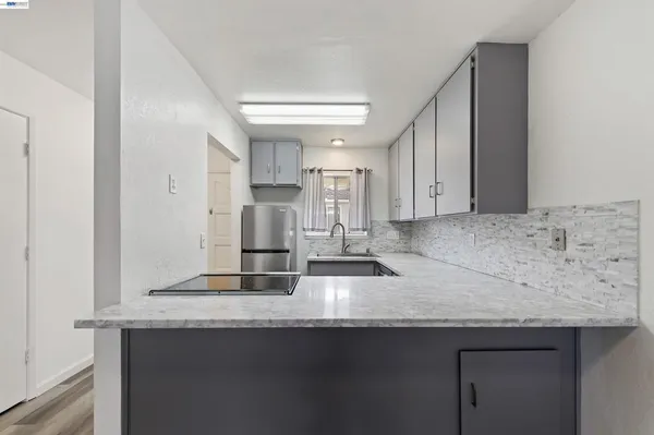 a kitchen with stainless steel appliances granite countertop a sink and a refrigerator