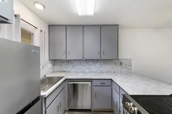 a kitchen with granite countertop cabinets stainless steel appliances and sink