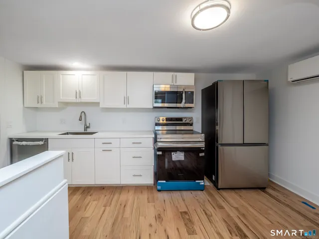 a kitchen with a refrigerator stove and wooden cabinets