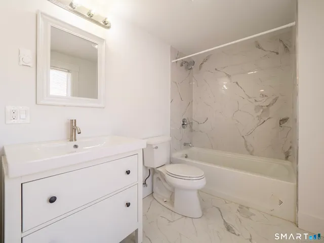 a bathroom with a sink toilet a mirror and shower