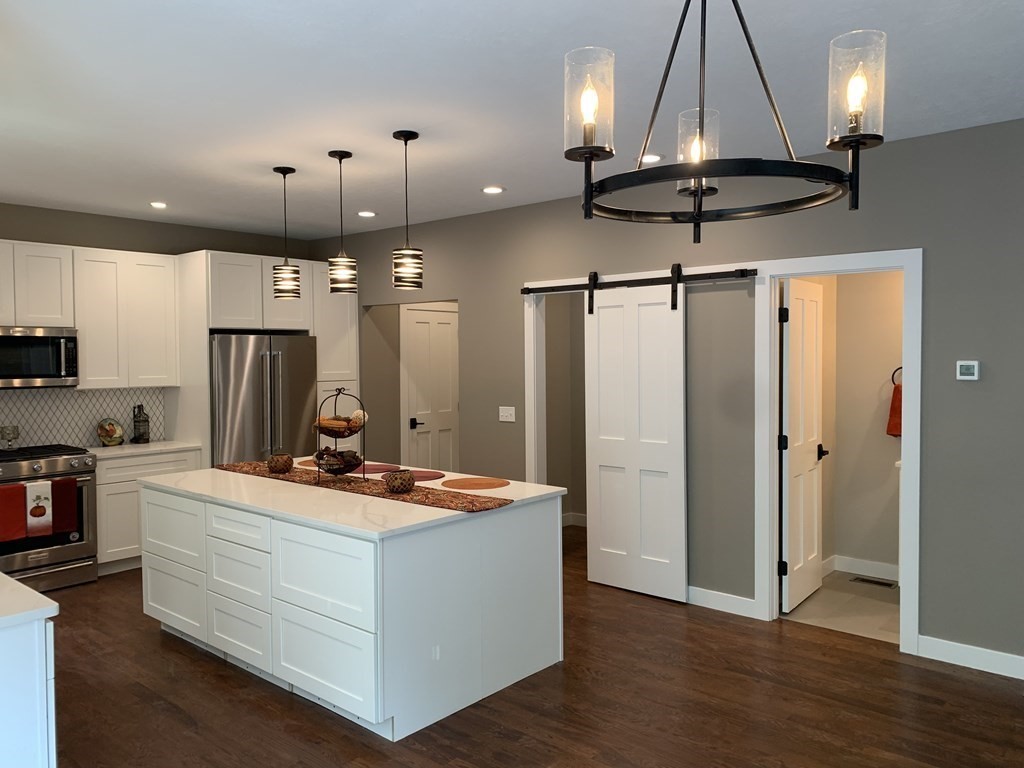 18 White Loaf Road Southampton, MA 01073 - Photo 3 of 20 a kitchen with stainless steel appliances a stove a refrigerator a dining table and chairs with wooden floor