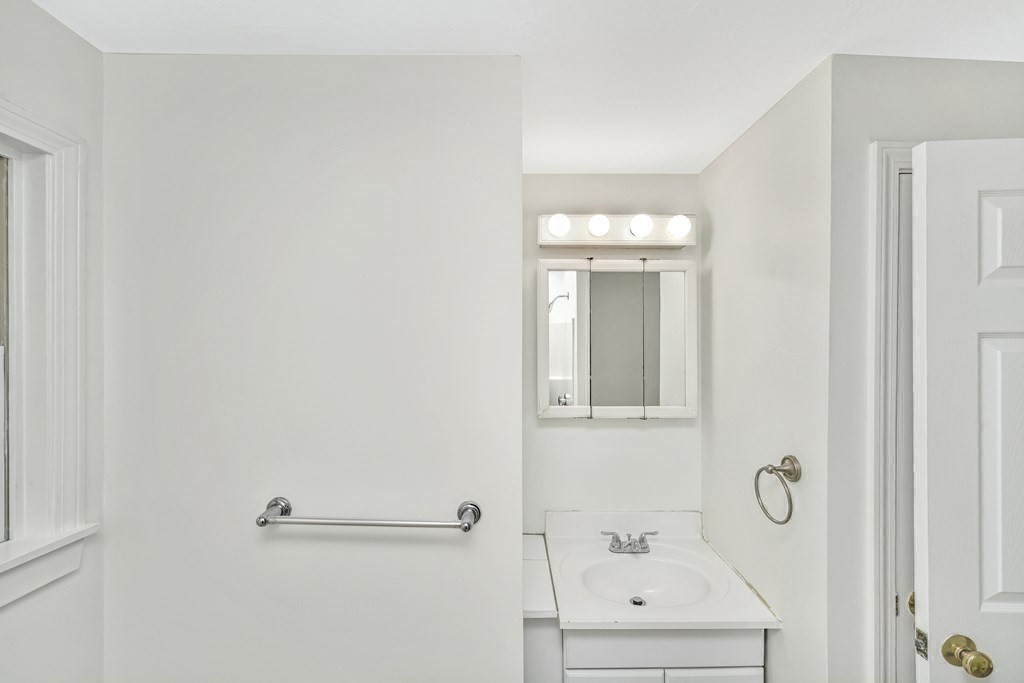 68 Marginal Street, Unit A Boston, MA 02128 - Photo 13 of 21 a bathroom with a sink a mirror and vanity