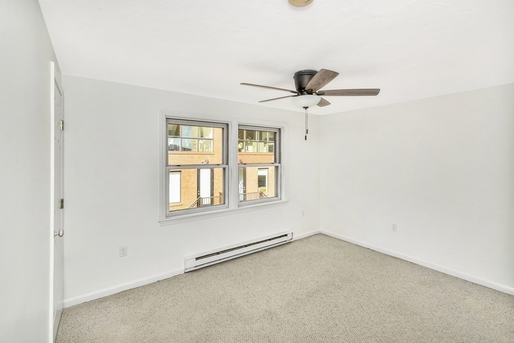 68 Marginal Street, Unit A Boston, MA 02128 - Photo 14 of 21 an empty room with a window and a ceiling fan