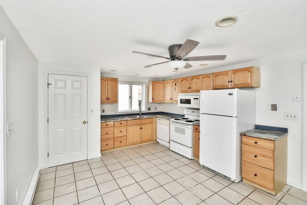 68 Marginal Street, Unit A Boston, MA 02128 - Photo 3 of 21 a kitchen with a refrigerator a stove top oven and cabinets