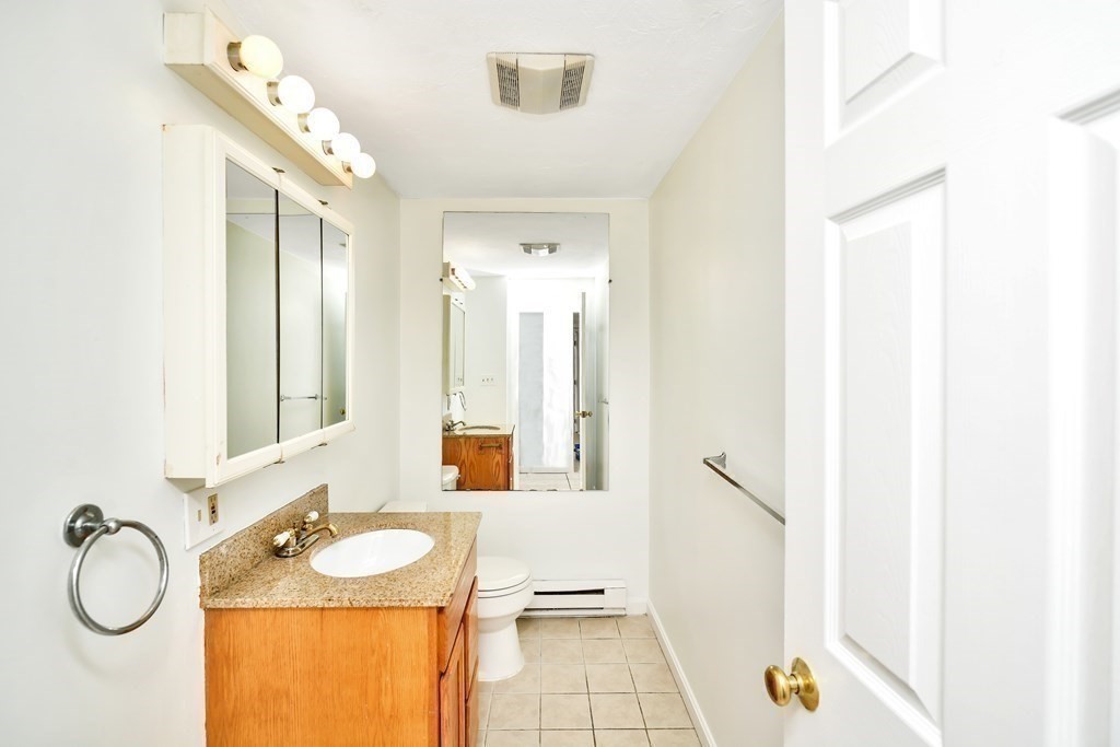 68 Marginal Street, Unit A Boston, MA 02128 - Photo 8 of 21 a bathroom with a granite countertop sink and a mirror