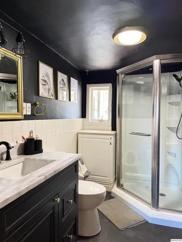 a bathroom with a double vanity sink toilet and shower