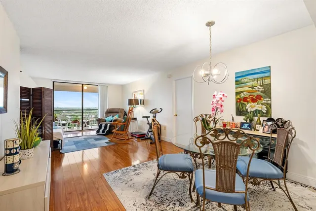 a view of a dining room and livingroom with furniture wooden floor a chandelier