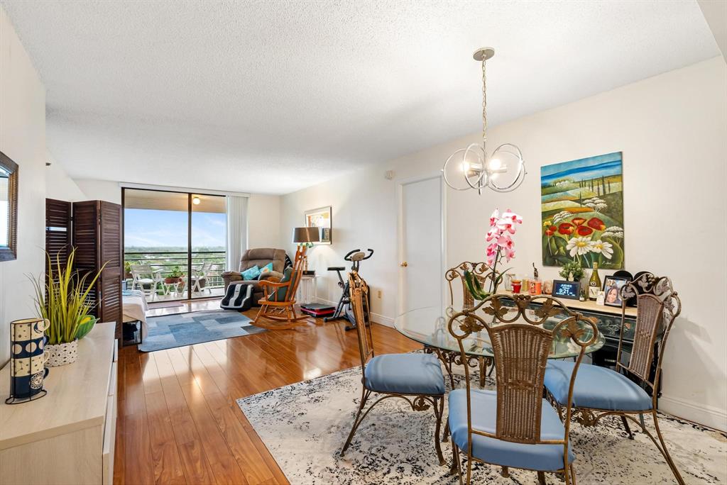 a view of a dining room and livingroom with furniture wooden floor a chandelier