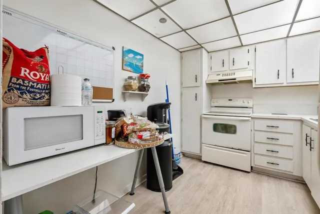 a room with a bed and a view of kitchen