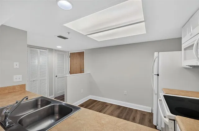 a view of an empty room with a kitchen