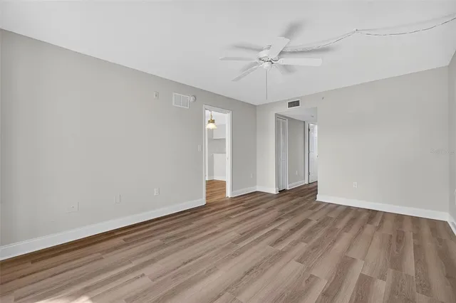 a view of an empty room with wooden floor