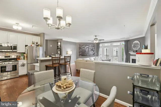 a dining room with furniture a kitchen view and wooden floor