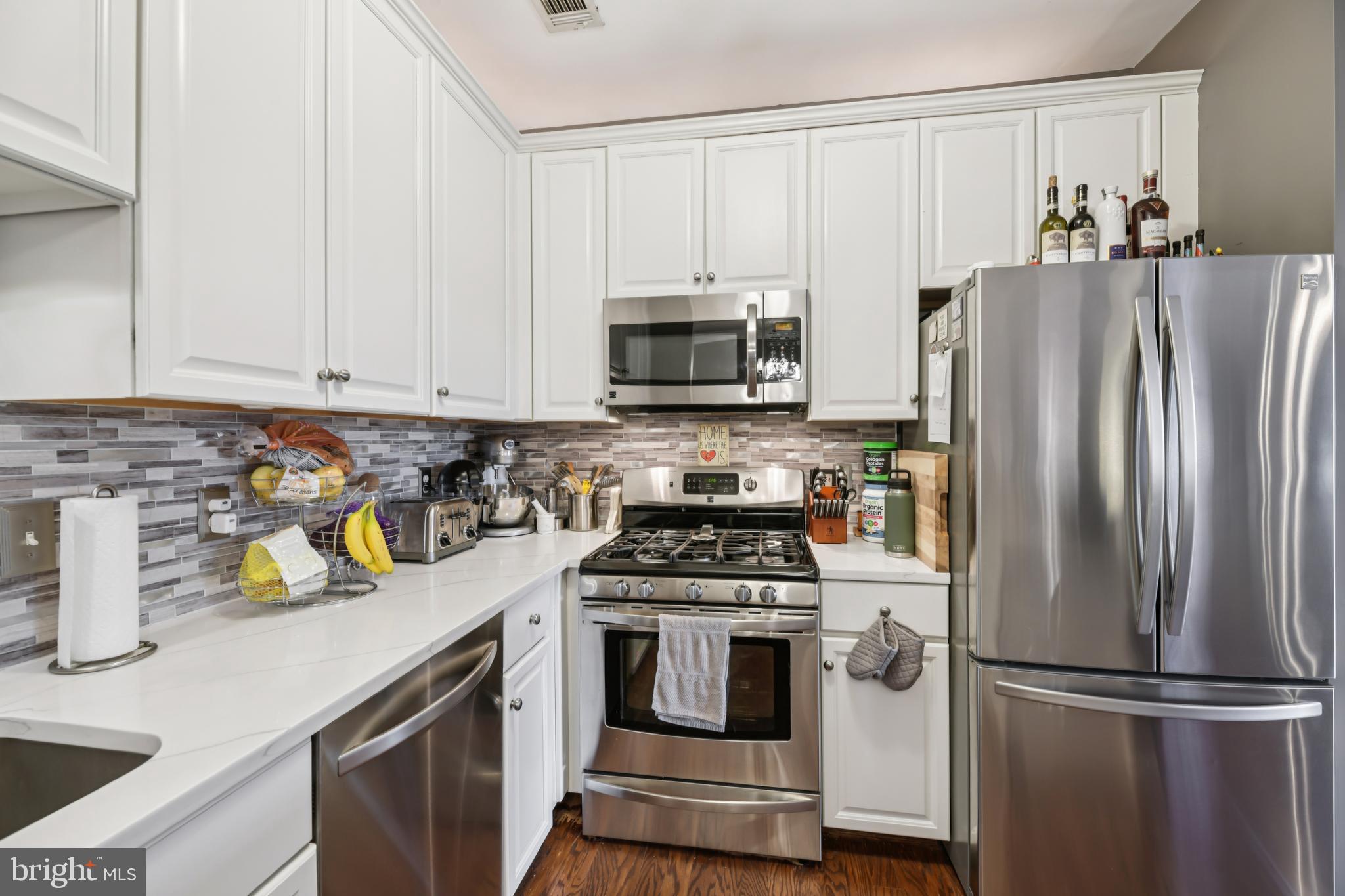 1621 Ladue Court, Unit 207 Woodbridge, VA 22191 - Photo 10 of 33 a kitchen with refrigerator a stove a sink and white cabinets