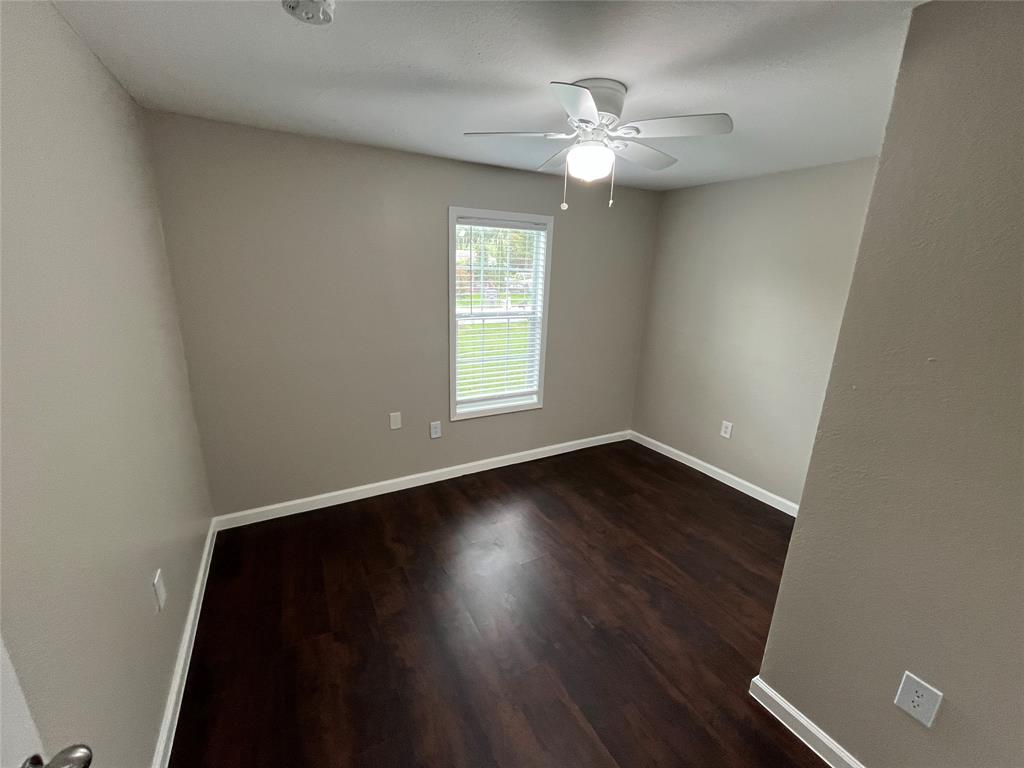 9558 Rylie Crest Drive Dallas, TX 75217 - Photo 9 of 14 Room featuring dark wood-finish flooring, light neutral-toned walls, and a white ceiling fan with integrated lighting