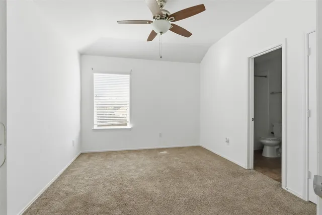 an empty room with a window and a ceiling fan