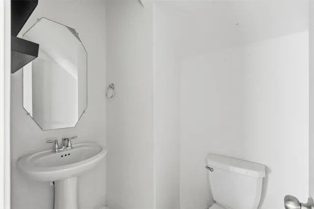 a bathroom with a toilet a sink and mirror