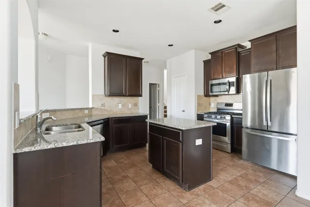 a kitchen with a sink stove and refrigerator