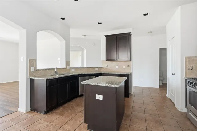 a kitchen with stainless steel appliances granite countertop a sink and a stove