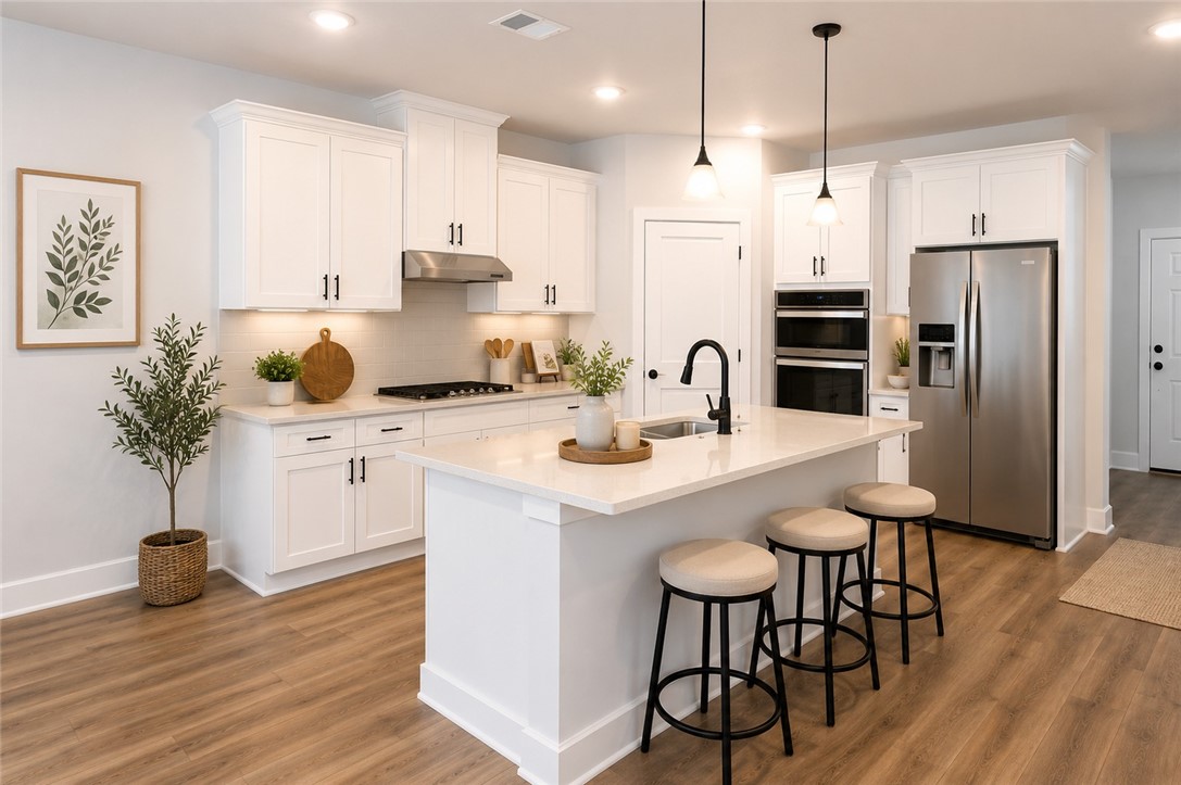 2004 Reagan Court Bryan, TX 77802 - Photo 6 of 19 a kitchen with stainless steel appliances kitchen island a table chairs refrigerator and sink