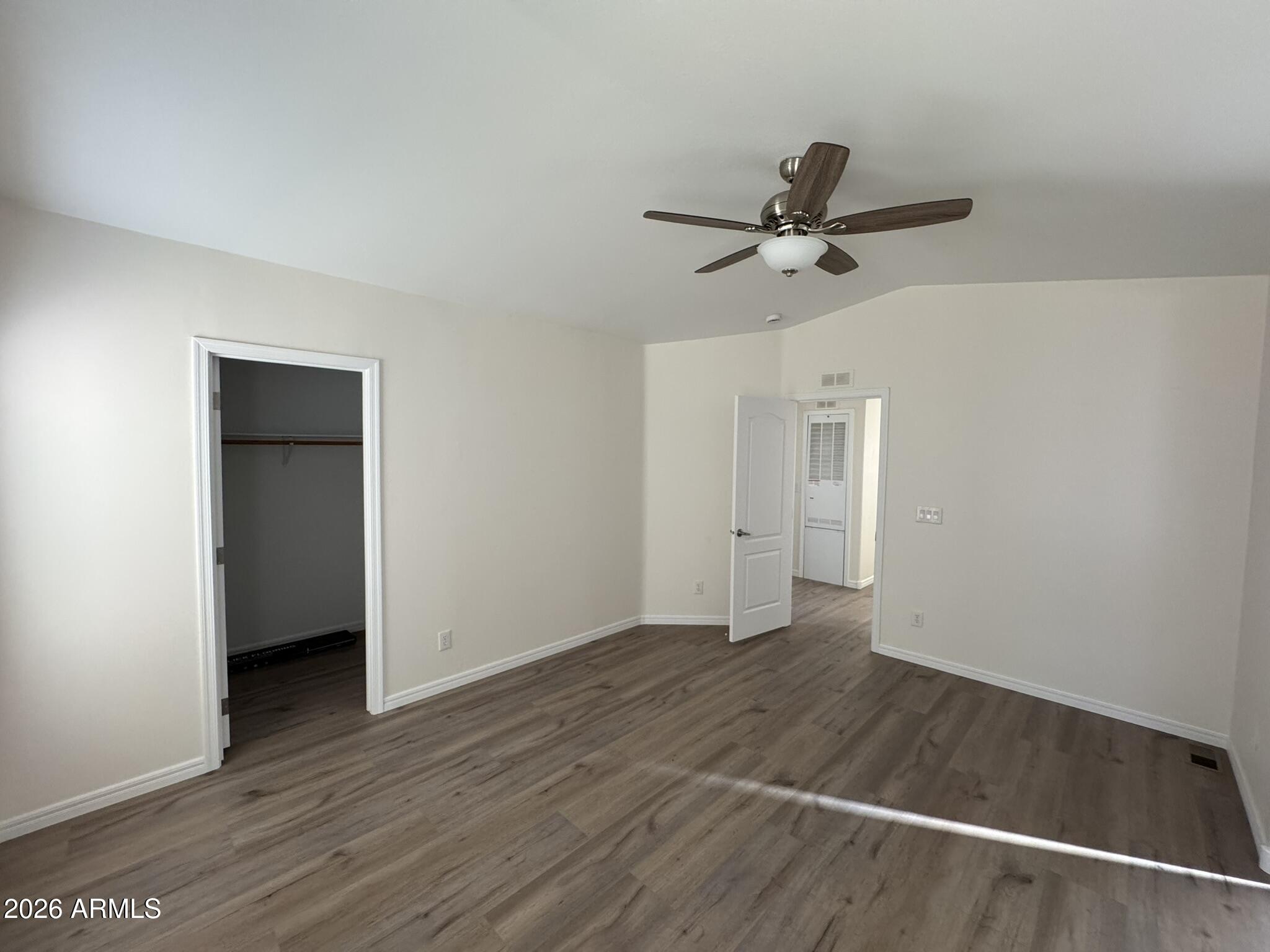 4123 Cowlic Road Golden Valley, AZ 86413 - Photo 15 of 15 an empty room with wooden floor and ceiling fan