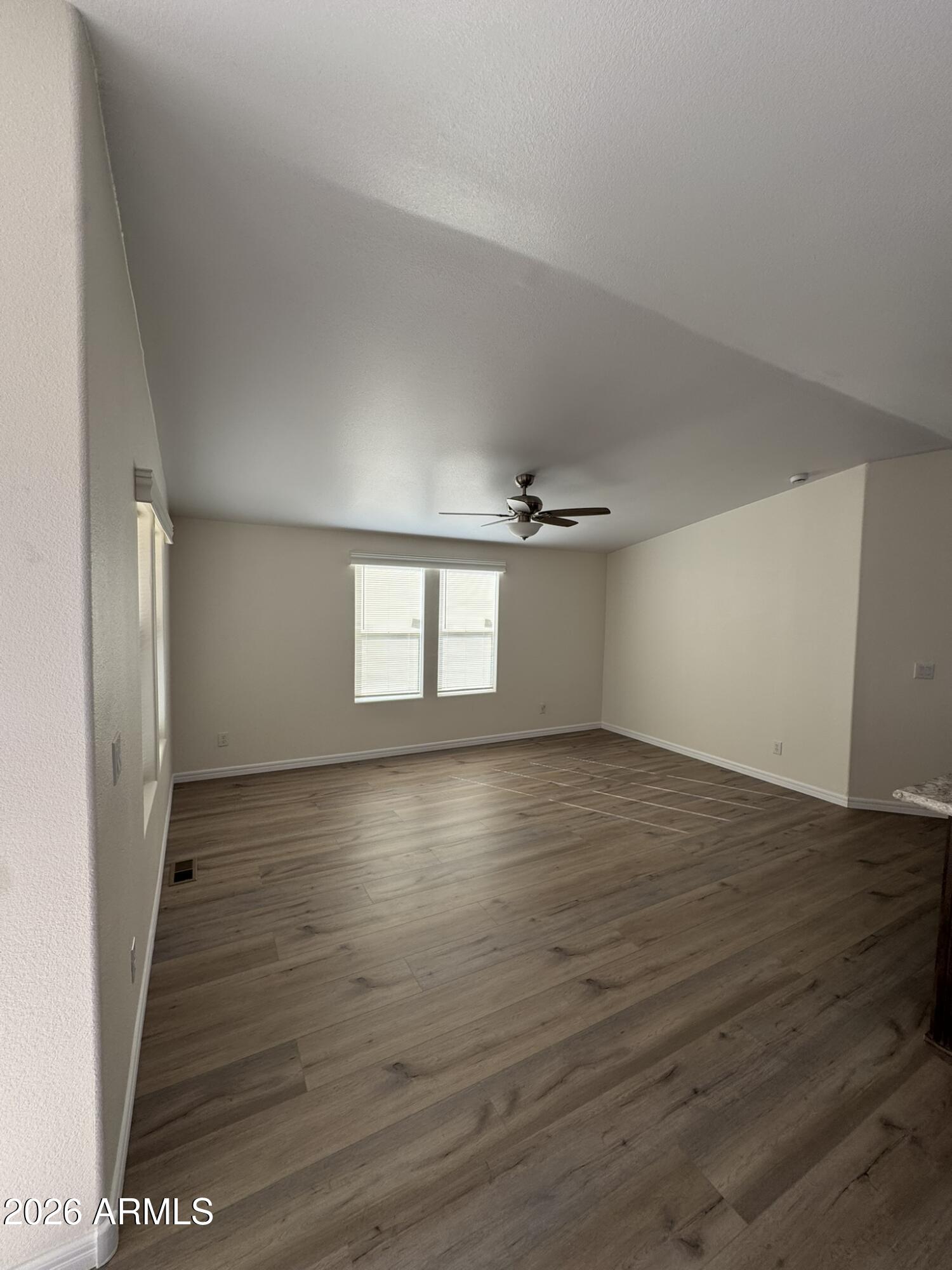 4123 Cowlic Road Golden Valley, AZ 86413 - Photo 4 of 15 a view of empty room with wooden floor and fan