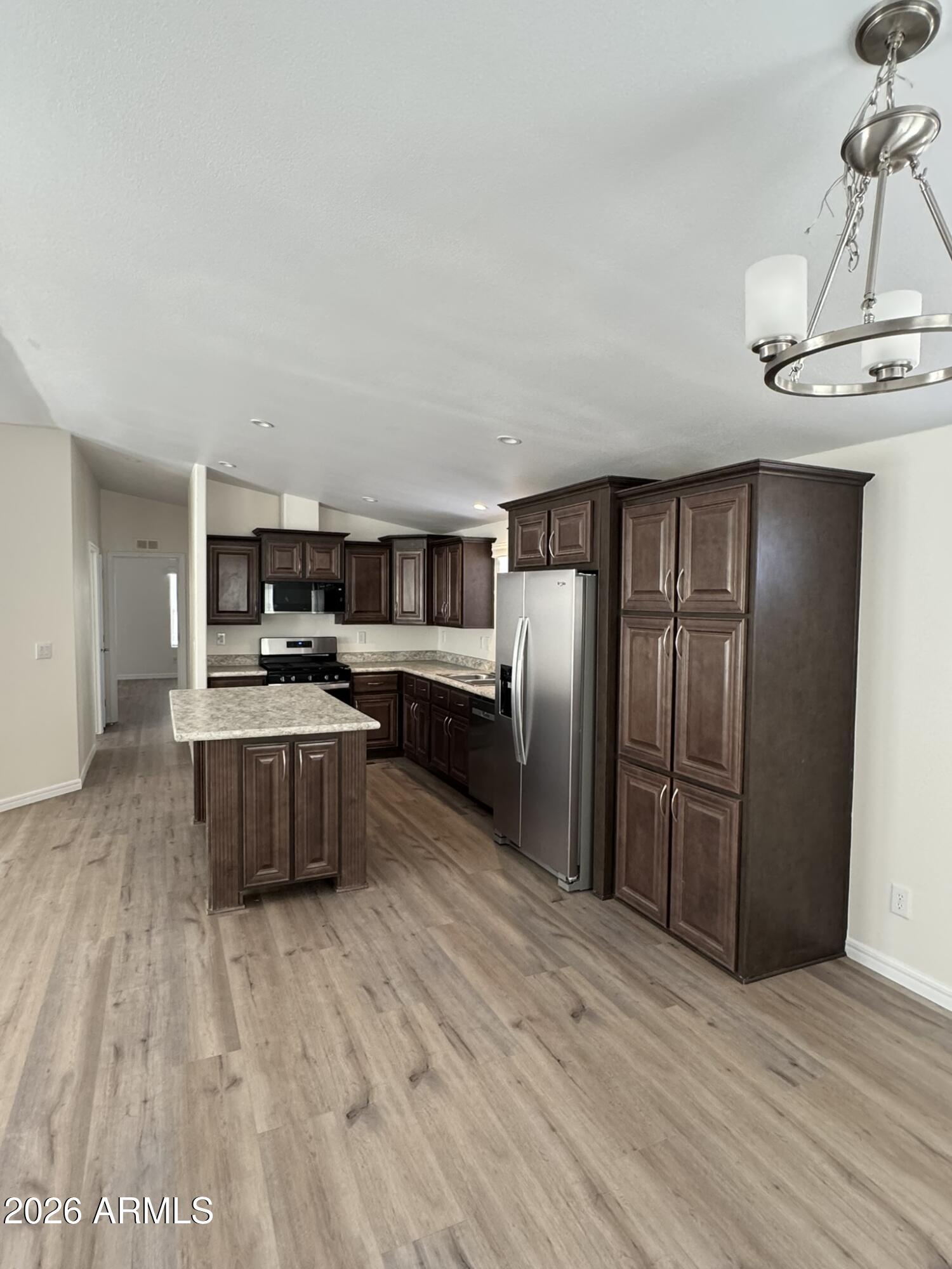 4123 Cowlic Road Golden Valley, AZ 86413 - Photo 5 of 15 a kitchen with stainless steel appliances kitchen island granite countertop a refrigerator and a stove top oven