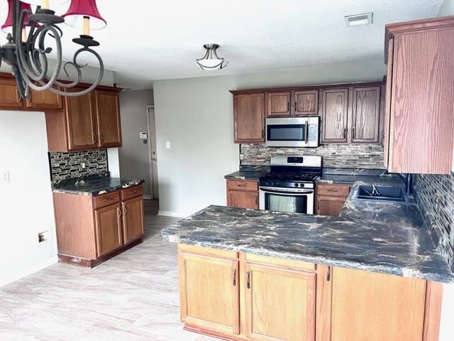 8375 Phillipson Way Memphis, TN 38125 - Photo 2 of 12 a kitchen with stainless steel appliances granite countertop a stove a sink and a microwave