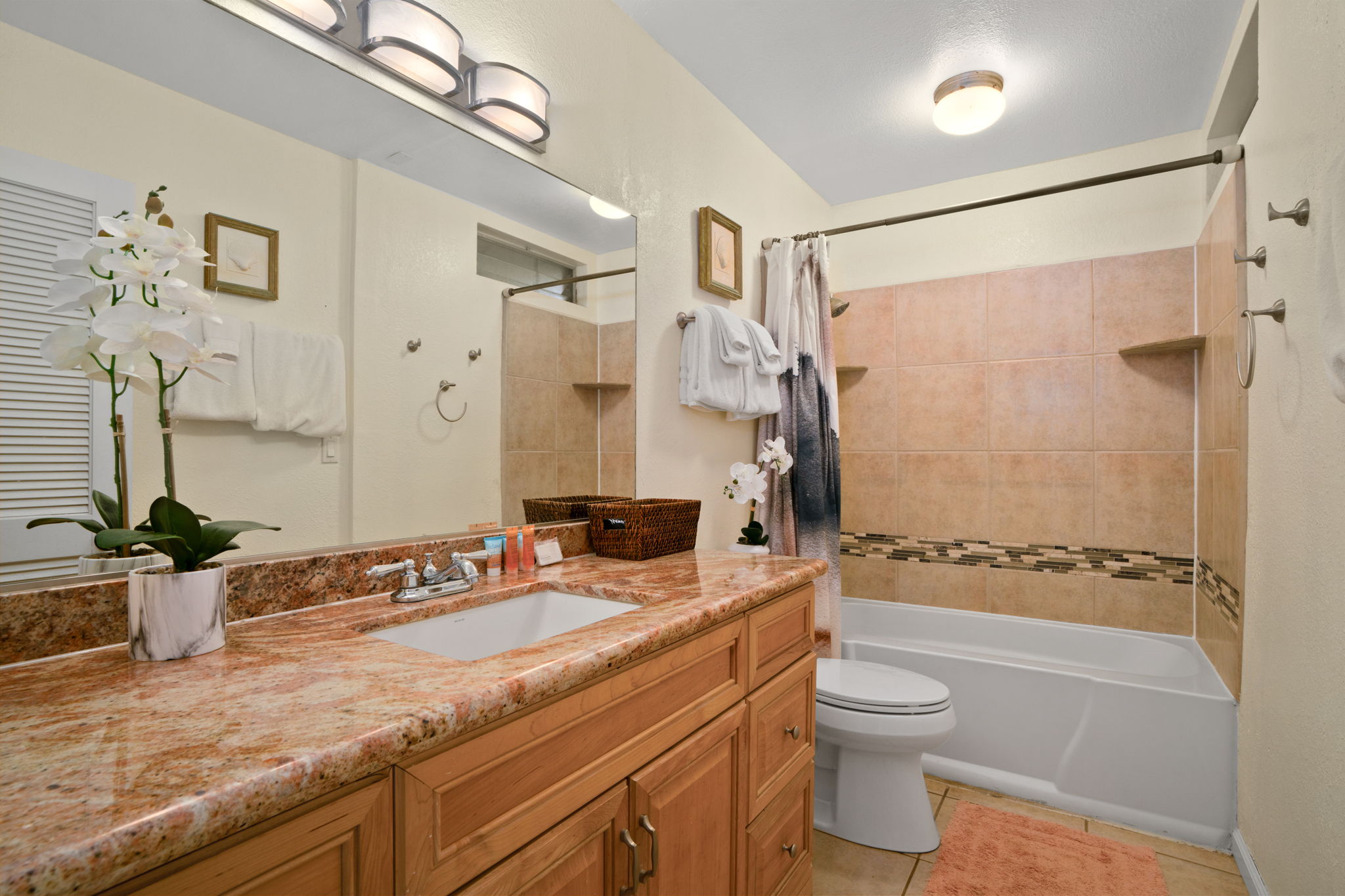 3880 Wyllie Road, Unit 20A Princeville, HI 96722 - Photo 5 of 28 a bathroom with a granite countertop sink toilet mirror and shower