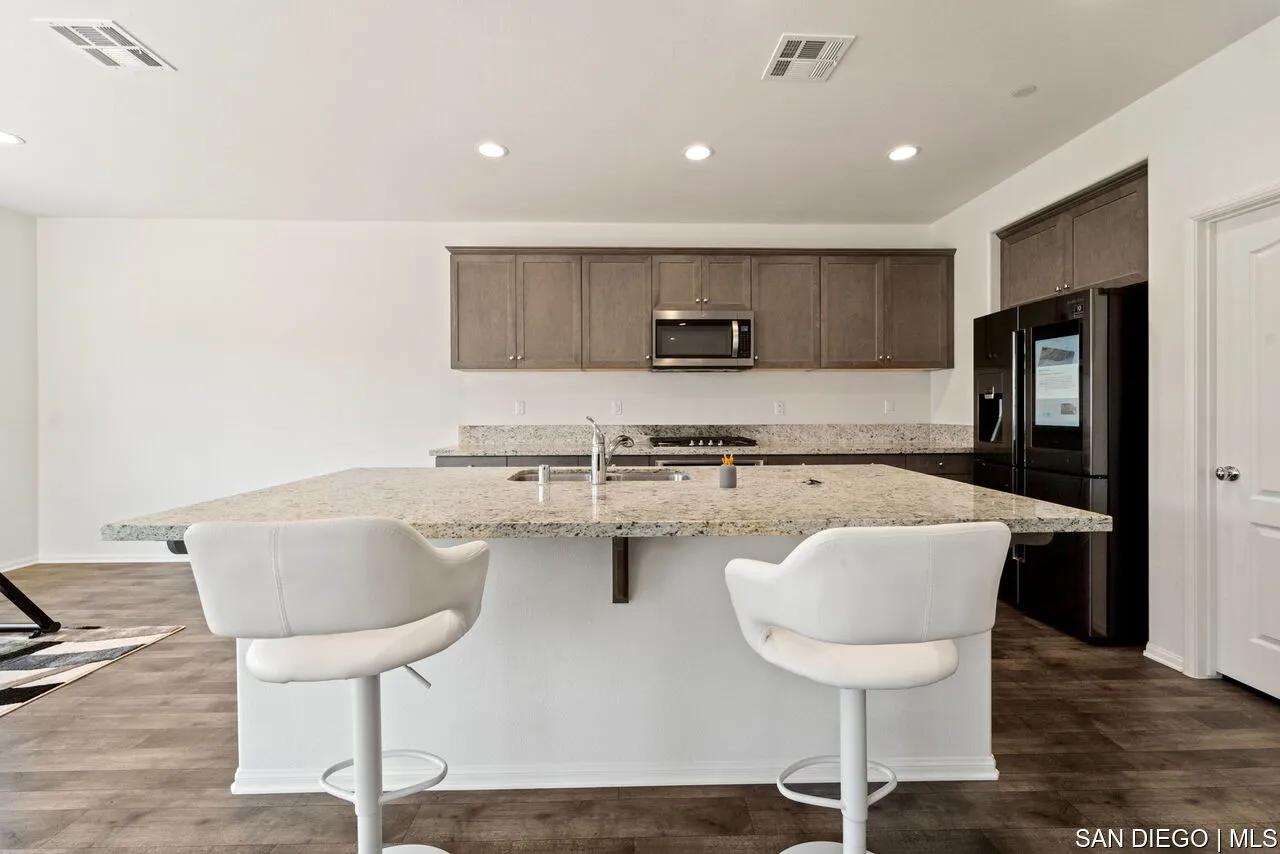 35858 Esperia Way Fallbrook, CA 92028 - Photo 12 of 37 a kitchen with stainless steel appliances granite countertop a sink and cabinets
