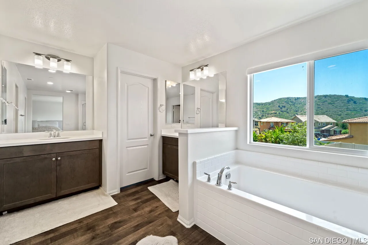 35858 Esperia Way Fallbrook, CA 92028 - Photo 22 of 37 a bathroom with a bathtub a double vanity sink a vanity and a large window