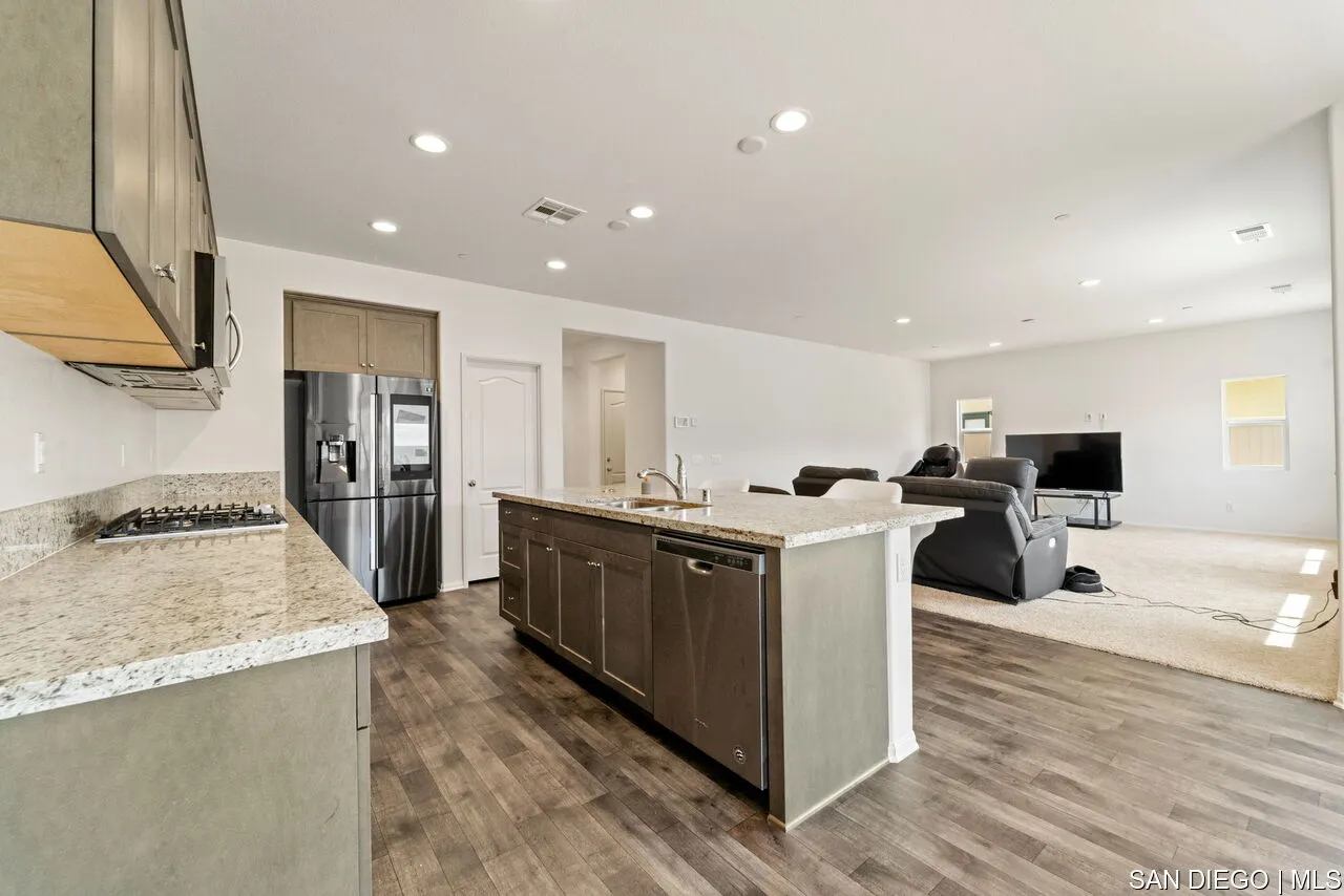 35858 Esperia Way Fallbrook, CA 92028 - Photo 7 of 37 a large kitchen with stainless steel appliances kitchen island granite countertop a large counter top and wooden floors
