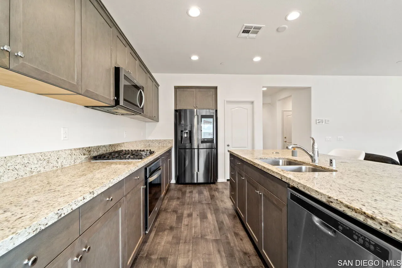 35858 Esperia Way Fallbrook, CA 92028 - Photo 9 of 37 a large kitchen with stainless steel appliances granite countertop a lot of counter space and wooden floor