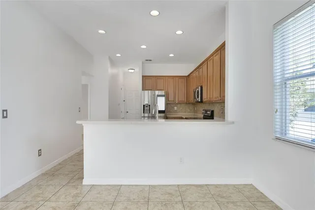 a view of kitchen with stainless steel appliances granite countertop a refrigerator sink and cabinets