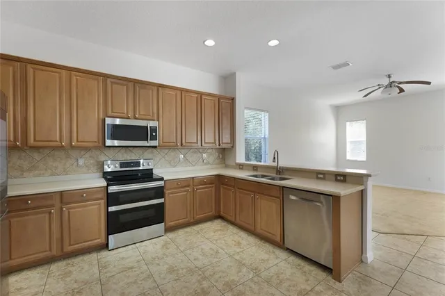 a kitchen with stainless steel appliances granite countertop white cabinets a sink and dishwasher