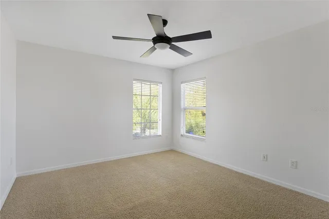 an empty room with a ceiling fan and painted walls