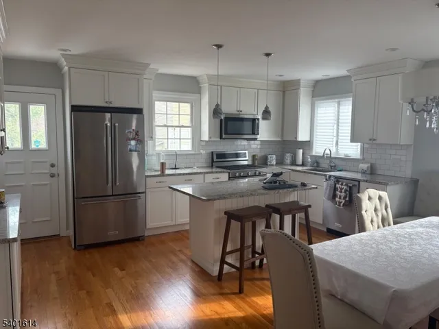 a kitchen with refrigerator cabinets and wooden floor